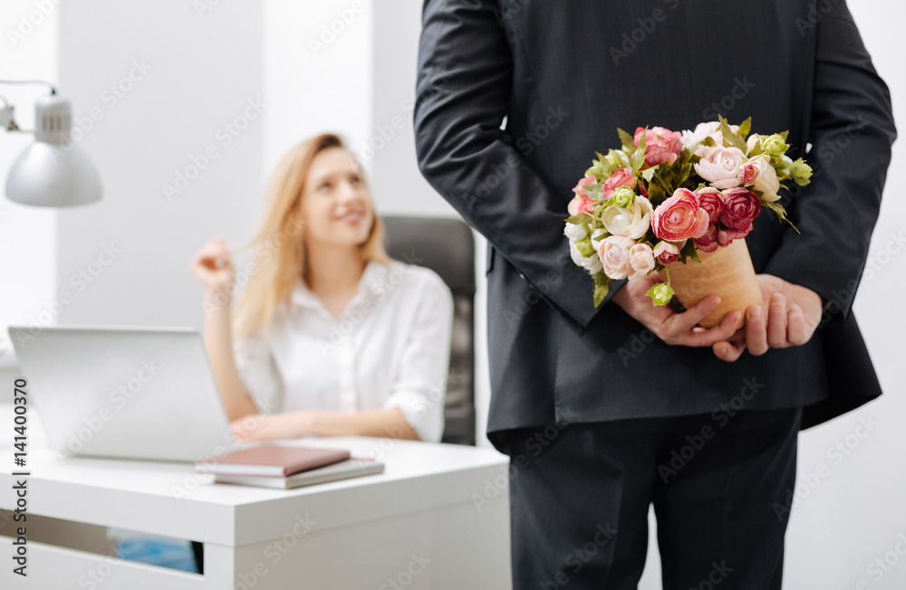 Attentive coworker having surprise for the colleague Attentive coworker having surprise for the colleague