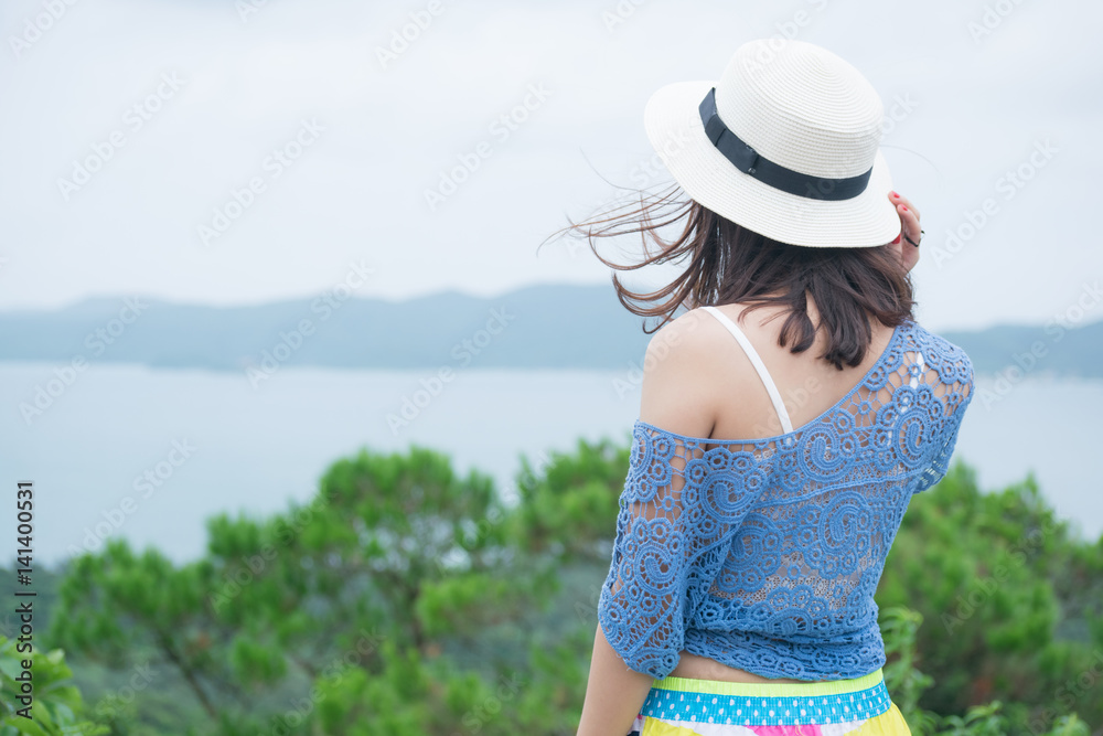 Vietnamese girl standing high overlooking the sea
