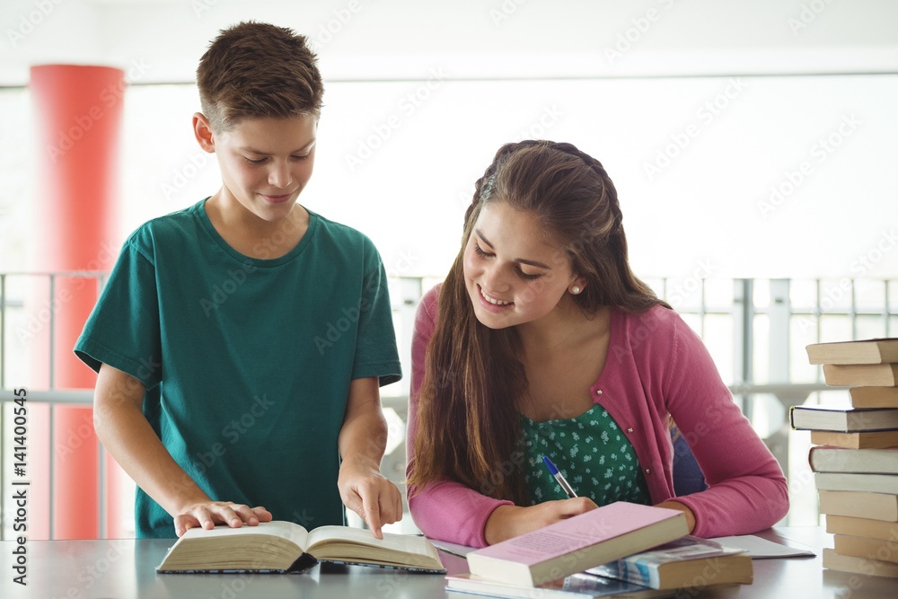 Fototapeta premium School kids doing homework in library at school