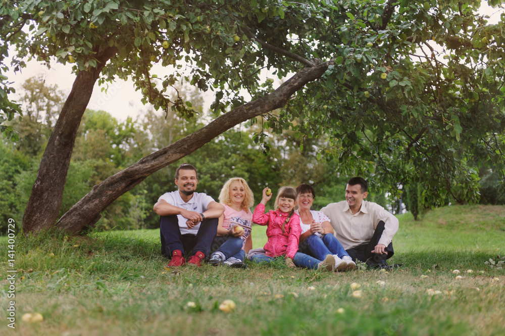 Happy Family have a rest under tree apple