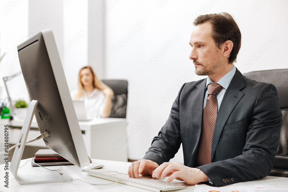 Confident businessman using computer in the office Confident businessman using computer in the office