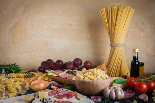 Pasta, tomatoes, salami and cheese on the table