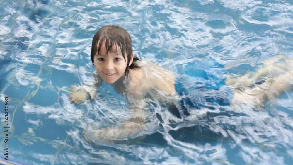 Sweet child, boy, swimming in a big swimming pool Sweet child, boy, swimming in a big swimming pool