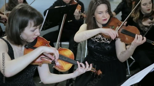 Close-up of musician playing violin on the symphony hall photo