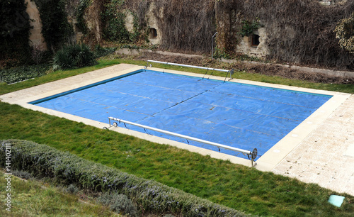 Pool protected with a blue tarp in winter