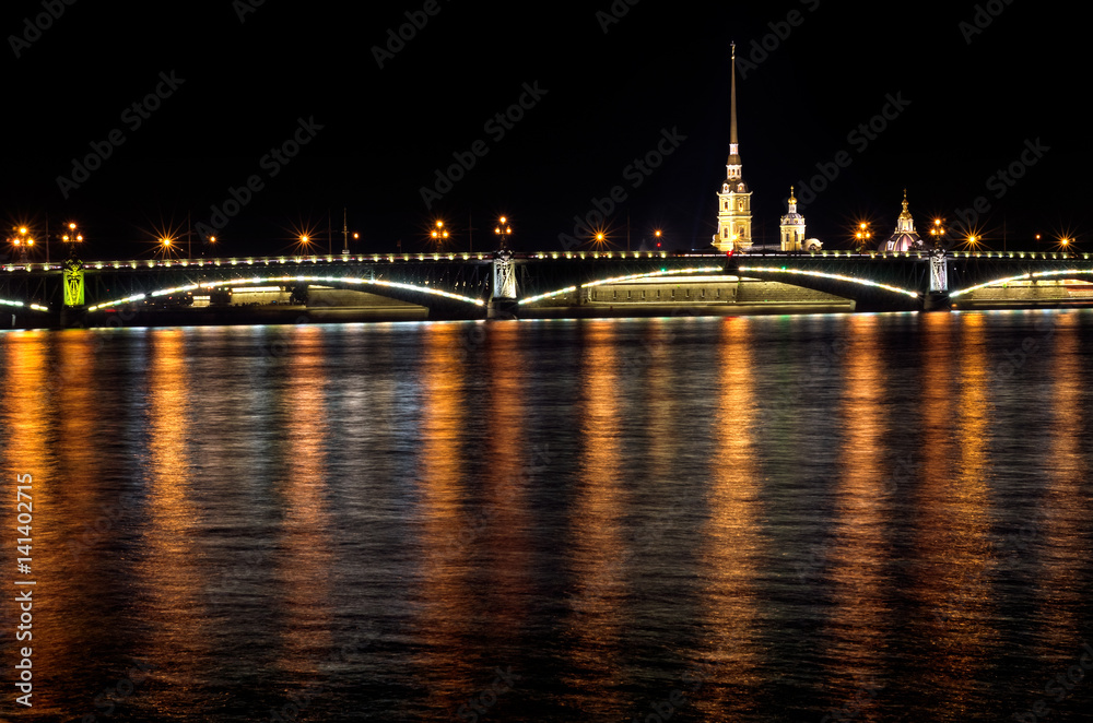 Night of St. Petersburg on the Neva, Peter and Paul fortress over the bridge and light reflections in the water