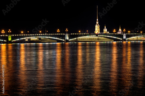Night of St. Petersburg on the Neva  Peter and Paul fortress over the bridge and light reflections in the water