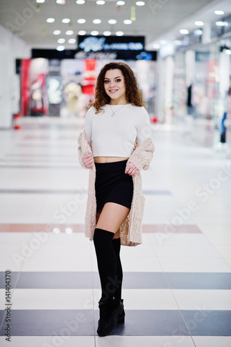 Young curly model girl posed on mini skirt at large shopping center. © AS Photo Family
