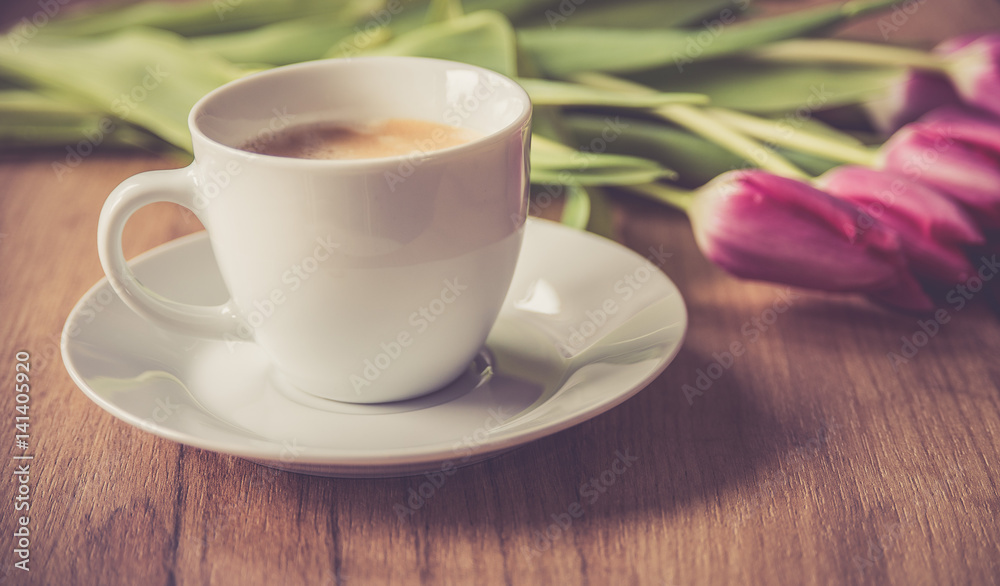 Fototapeta premium coffee cup with tulips on wooden back ground