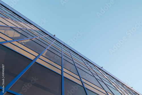 The glass facade on the background of blue sky