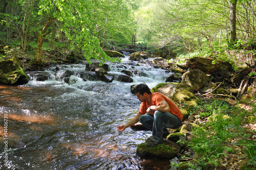 Man drinking water from the river. Clean unpolluted water in the river, 