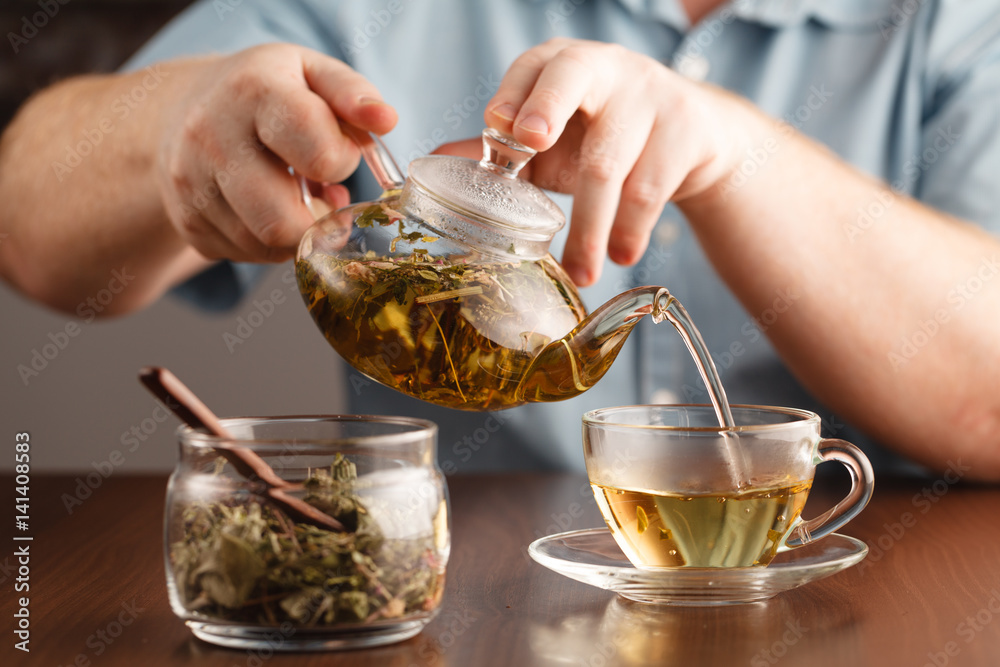 mans hands and glass cup of medicine herbal tea mans hands and glass cup of medicine herbal tea