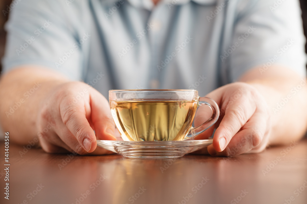 Man hold cup in hand and offer tea Man hold cup in hand and offer tea