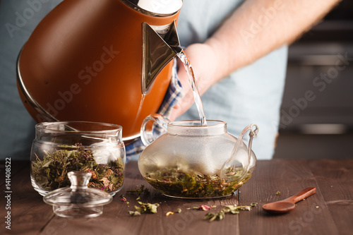 man pouring herbal tea in the glass