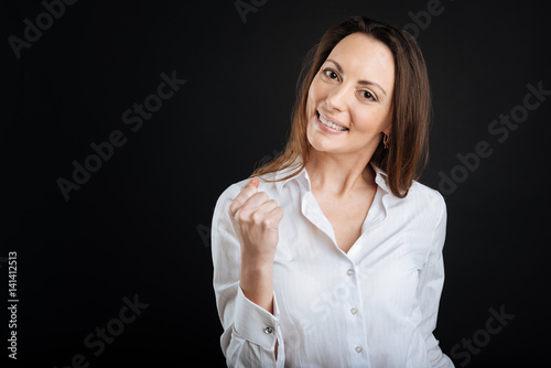 Successful young brunette making fist