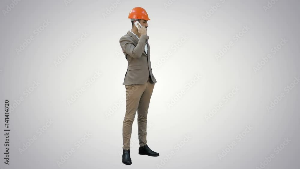 Contractor in hardhat talking on mobile phone on white background. Contractor in hardhat talking on mobile phone on white background.