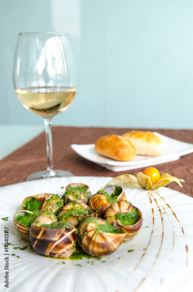 Snails with sauce and cup of white wine