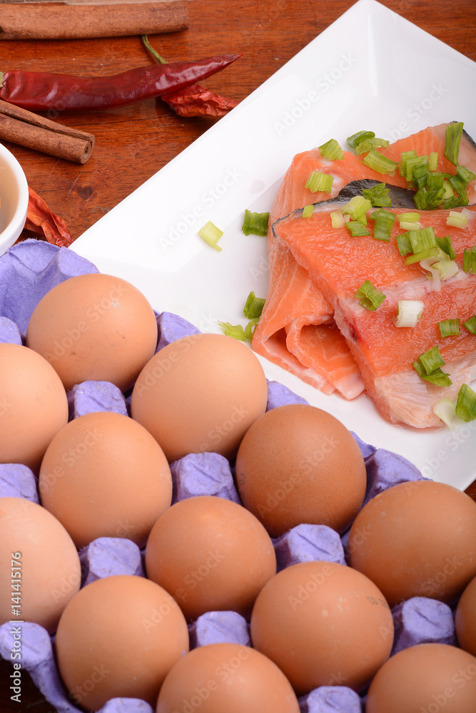 fresh salmon fillet close up on white plate. red pepper, eggs and lemon fresh salmon fillet close up on white plate. red pepper, eggs and lemon