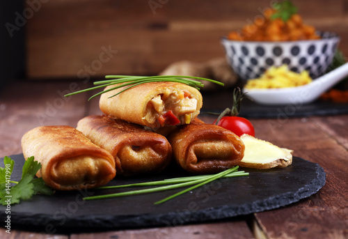 Crispy golden fried spring rolls with fresh ingredients served in an oriental restaurant