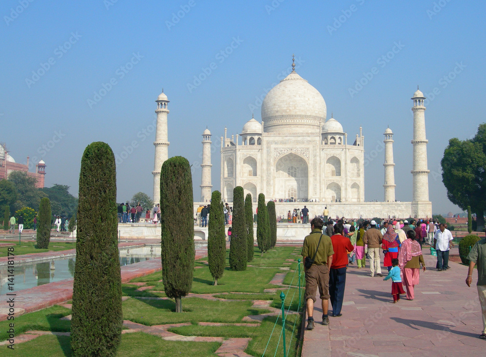 Obraz premium Side perspective of the Taj Mahal mausoleum in Agra, India, with the main building dome framed by the minaret towers and the reflection pool.