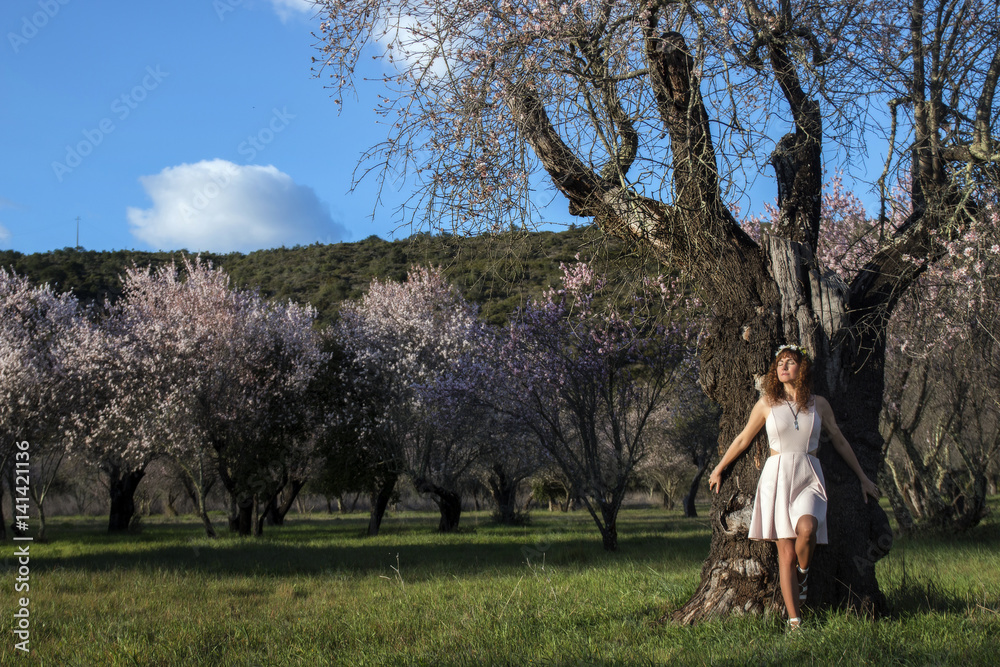 beautiful woman next to a almond tree beautiful woman next to a almond tree