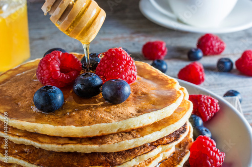 delicious pancakes with berries and honey