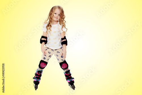 Little girl roller-skates.