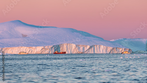 Tourists take pictures of the iceberg. Source of icebergs is by the Jakobshavn glacier. This is a consequence of the phenomenon of global warming and catastrophic thawing of ice, Disko Bay, Greenland photo
