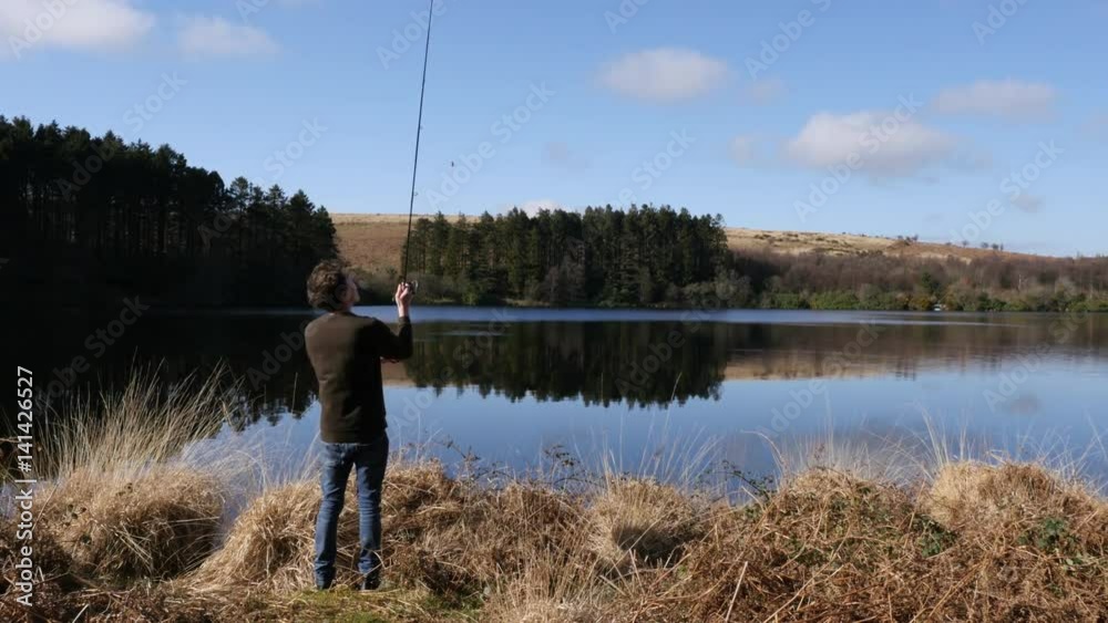 Fisherman casting into a lake Fisherman casting into a lake