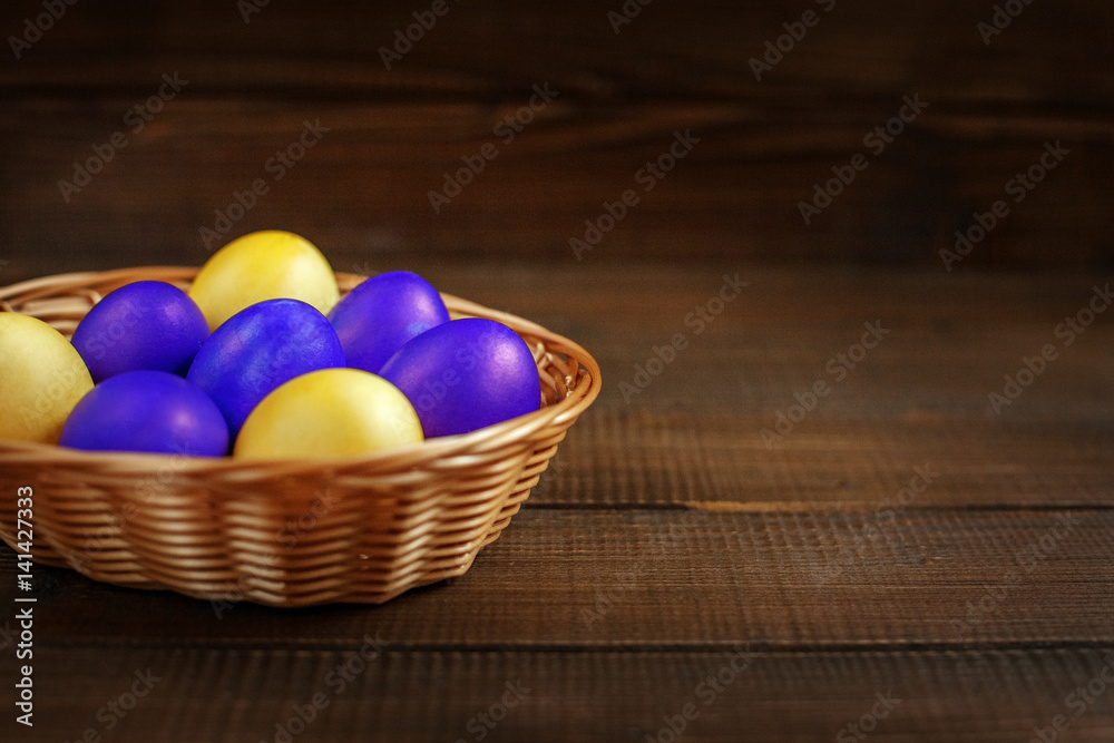 Yellow and purple Easter eggs in the basket. The concept of a holiday and a happy Easter Yellow and purple Easter eggs in the basket. The concept of a holiday and a happy Easter