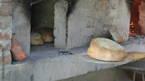 Take Out Bread with Wooden Shovel from Oven