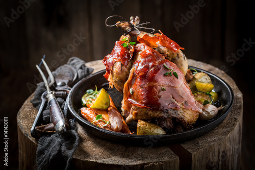 Grilled pheasant with bacon and vegetables and spices photo