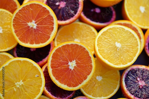 Tray of oranges, blood oranges, and cara cara oranges cut in half 