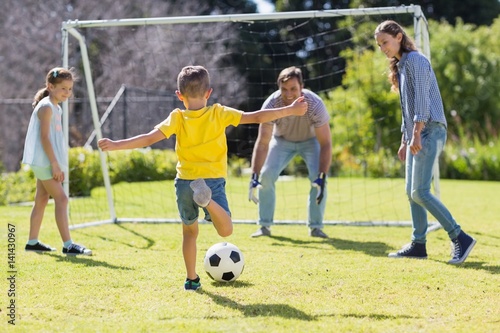 Happy family playing football in the park