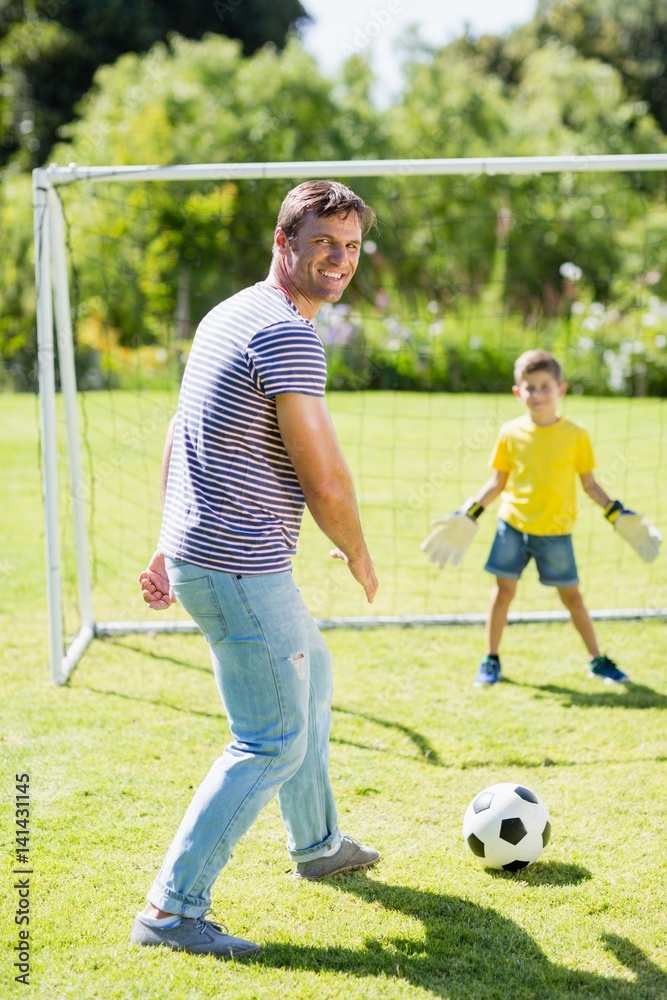 Obraz premium Father and son playing football in the park