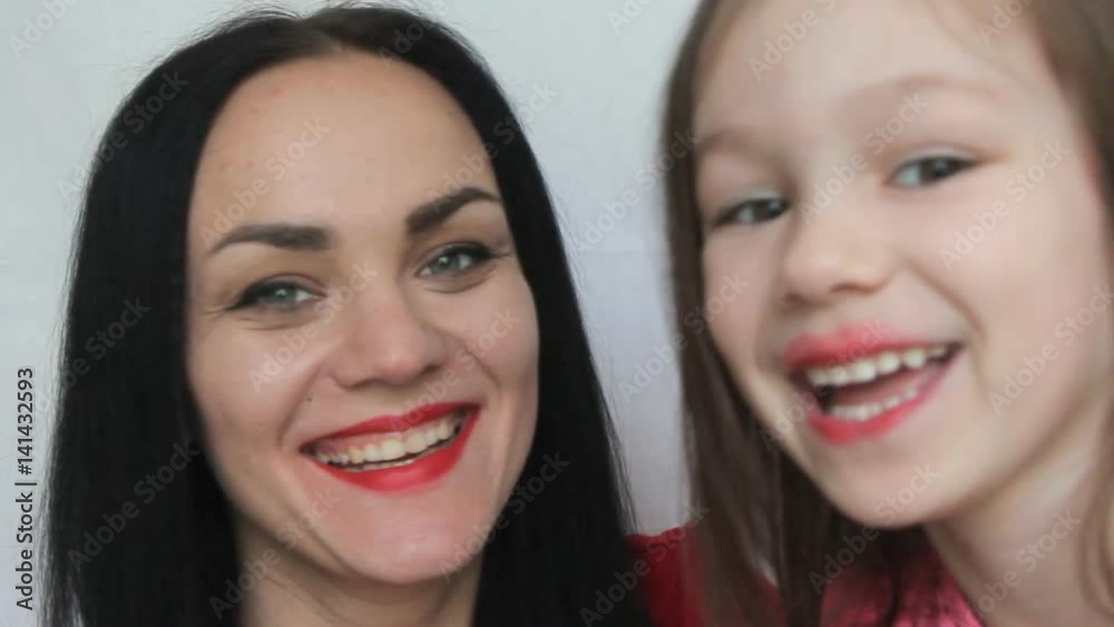 mother and daughter with red lips are having fun mother and daughter with red lips are having fun