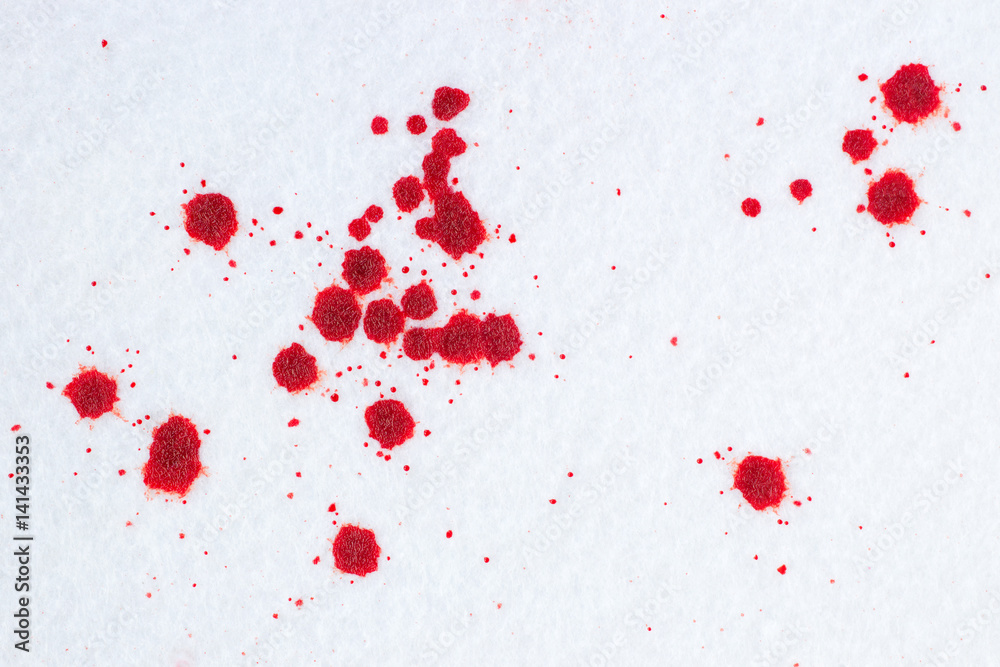 Red blood drops on white snow-liked felt background