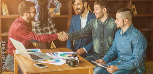 advertising Manager with a handshake greets the customer