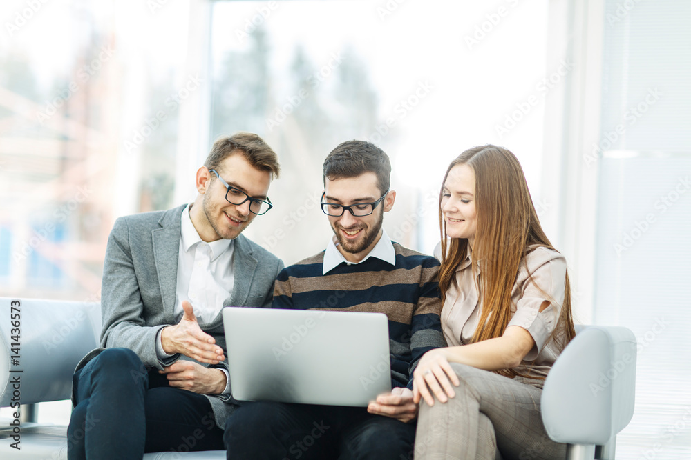  employees with a laptop sitting in the lobby of the office