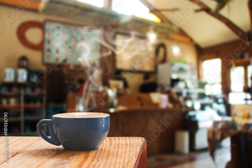 Coffee cup on wood table in cafe.