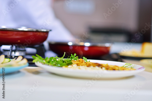 Man's hand holding an egg. White chicken egg. Chef starts preparing omelet.