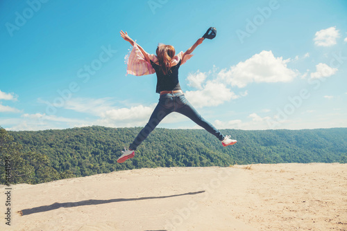 young woman Jumping at mountain view for sun light