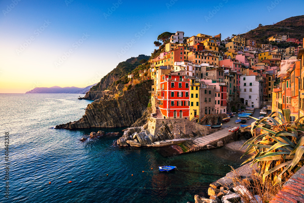 Riomaggiore town, cape and sea landscape at sunset. Cinque Terre, Liguria, Italy