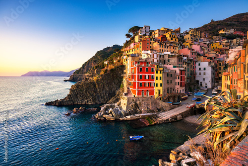 Riomaggiore town, cape and sea landscape at sunset. Cinque Terre, Liguria, Italy photo