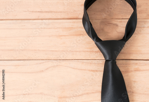 the black neck tie on wooden background photo