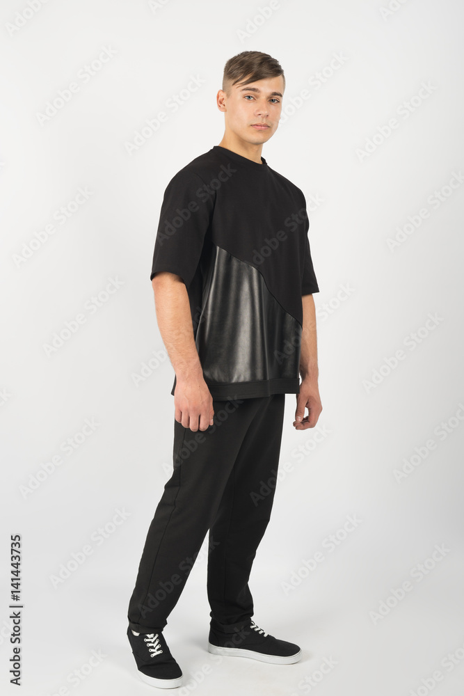 Young muscular man wearing black clothes and sneakers Young muscular man wearing black clothes and sneakers