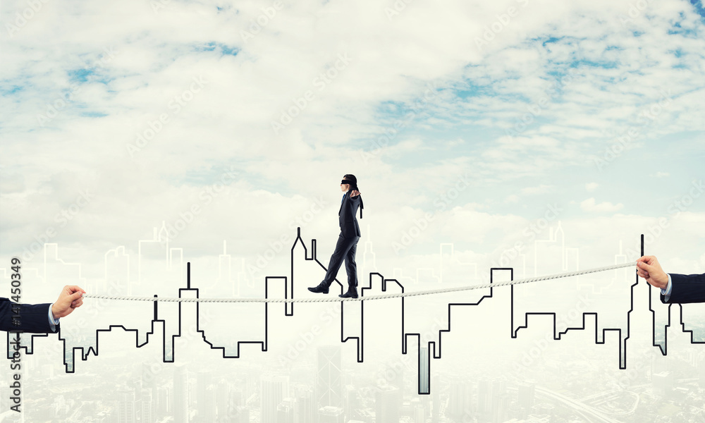 Business concept of risk support and assistance with man balancing on rope Business concept of risk support and assistance with man balancing on rope