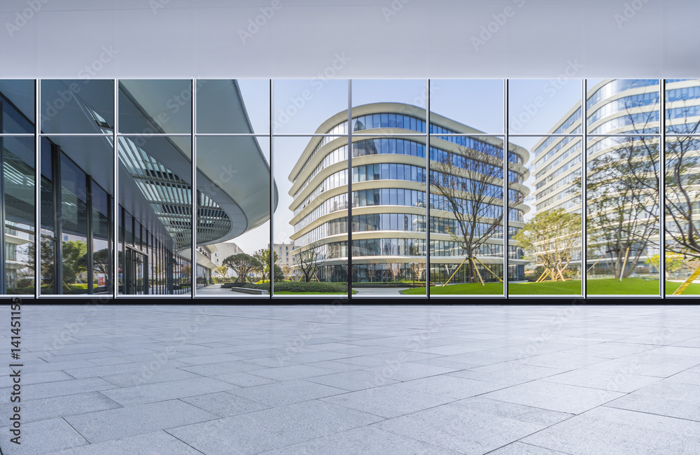 Fototapeta premium The modern office buildings from glass window