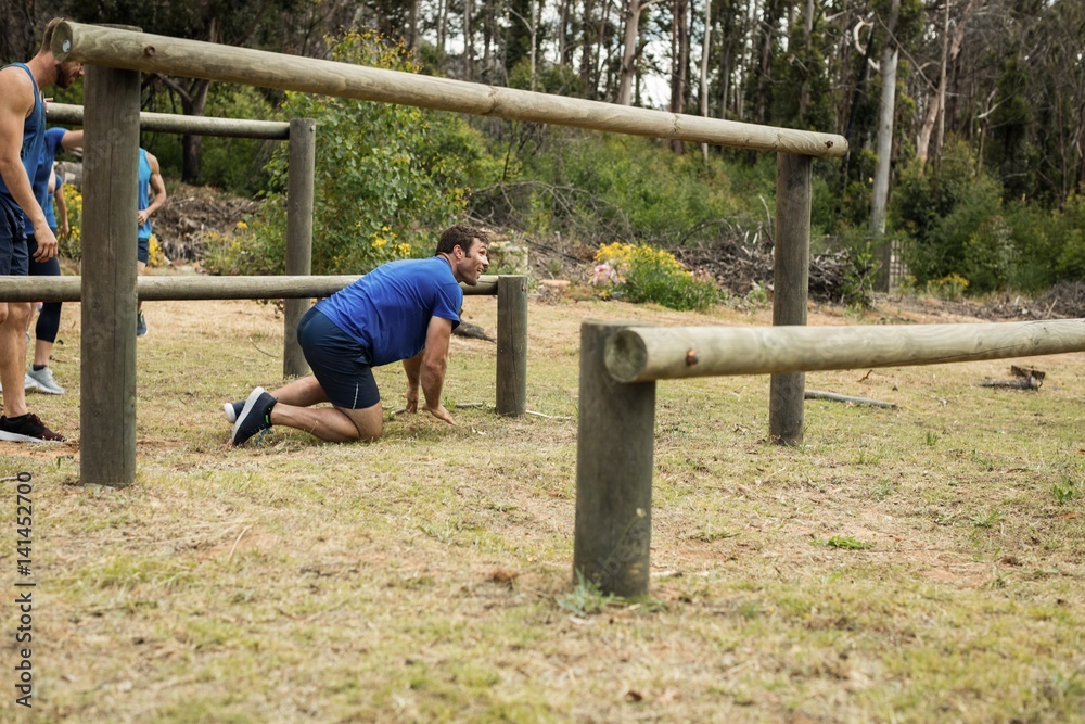 Man passing through hurdles during obstacle course Man passing through hurdles during obstacle course