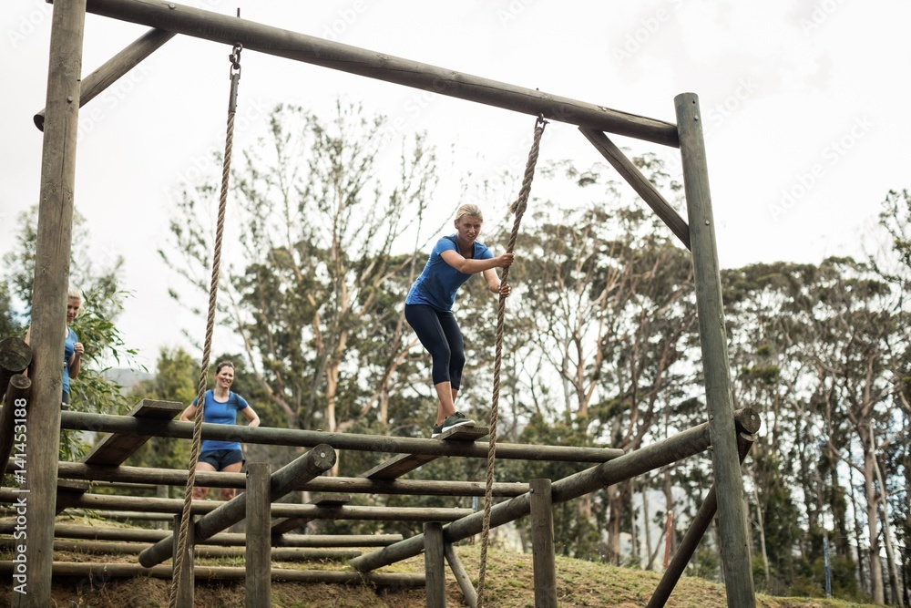 Fit woman holding the rope during obstacle course Fit woman holding the rope during obstacle course